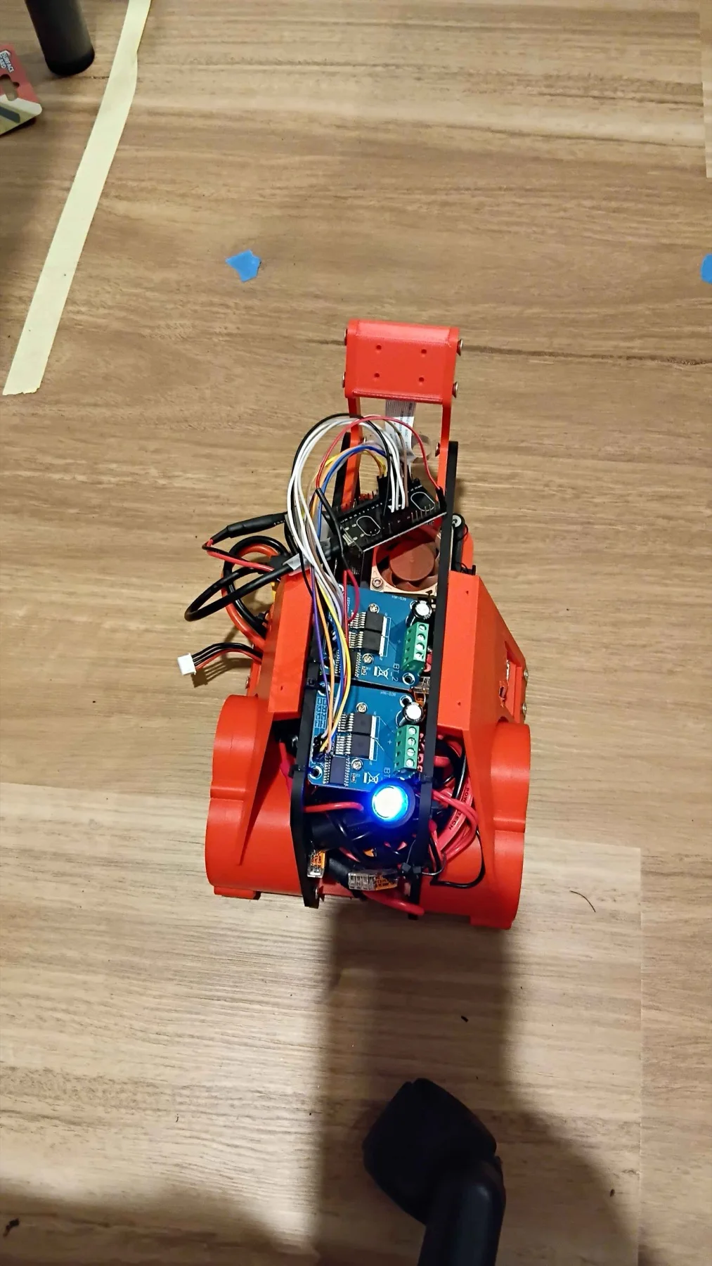 The Droid Racing Challenge car: 3D-printed orange chassis with a mast-mounted camera, dual motor driver boards and onboard compute