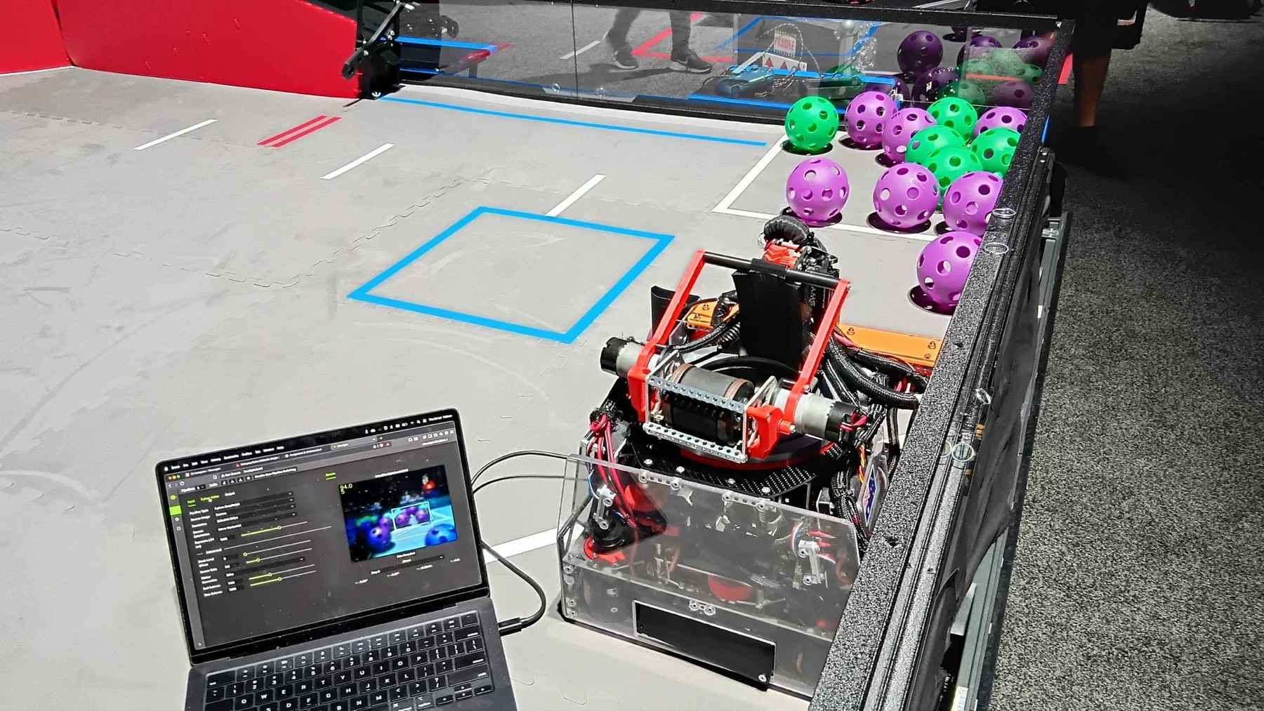Our FTC DECODE robot on the competition field, with the vision pipeline being tuned on a laptop alongside it